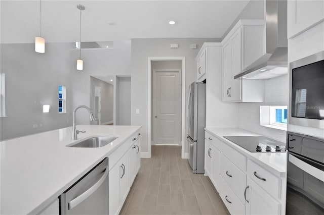 kitchen featuring wall chimney exhaust hood, black appliances, sink, pendant lighting, and white cabinets