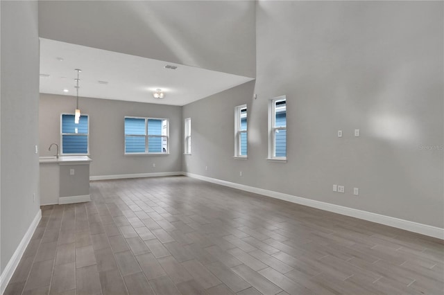 unfurnished living room featuring hardwood / wood-style floors and sink