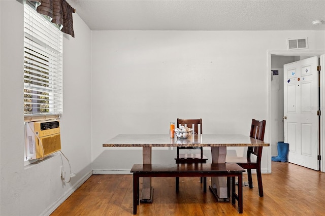 dining space with a textured ceiling and hardwood / wood-style flooring