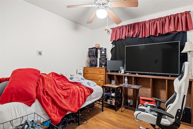 bedroom featuring hardwood / wood-style floors, a textured ceiling, and ceiling fan