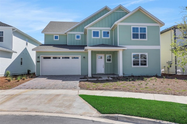 craftsman-style house with board and batten siding, a shingled roof, driveway, and a garage