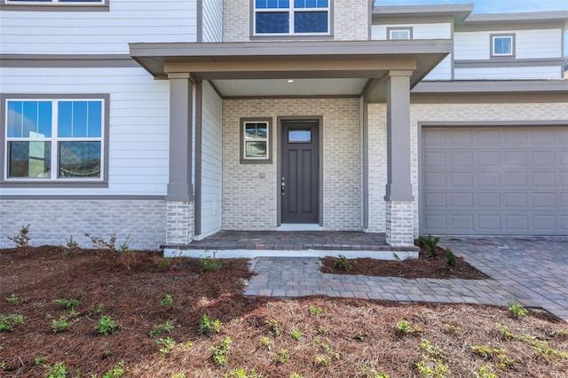 doorway to property featuring a porch and a garage