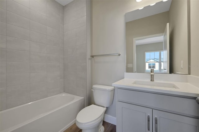 full bathroom with hardwood / wood-style flooring, toilet, vanity, and tiled shower / bath combo