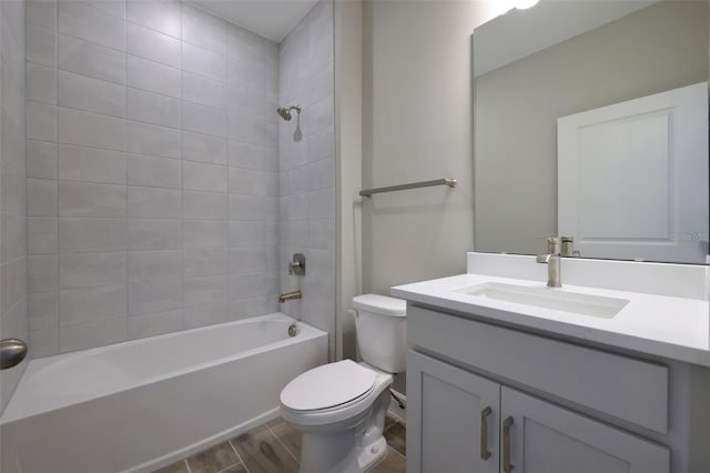 full bathroom featuring tiled shower / bath combo, vanity, and toilet