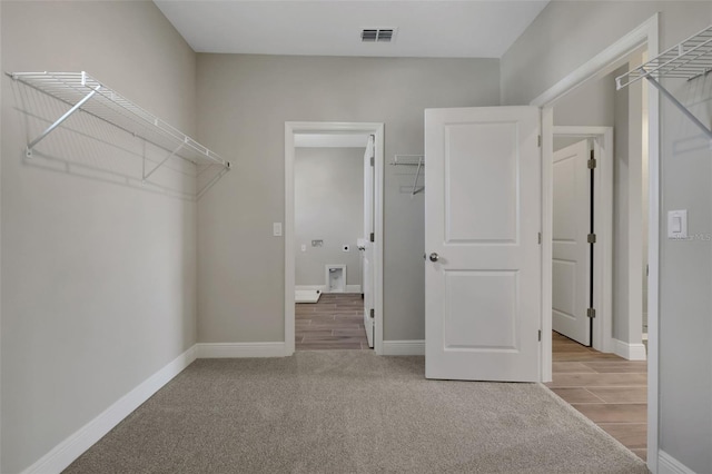 walk in closet featuring light carpet