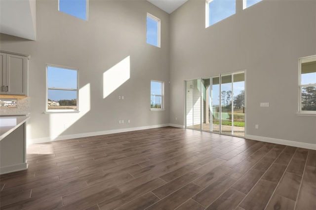 unfurnished living room with a healthy amount of sunlight and dark hardwood / wood-style floors