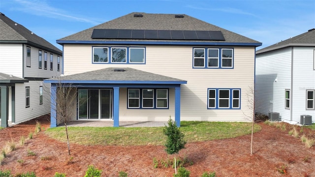 rear view of property featuring central air condition unit, solar panels, and a patio area