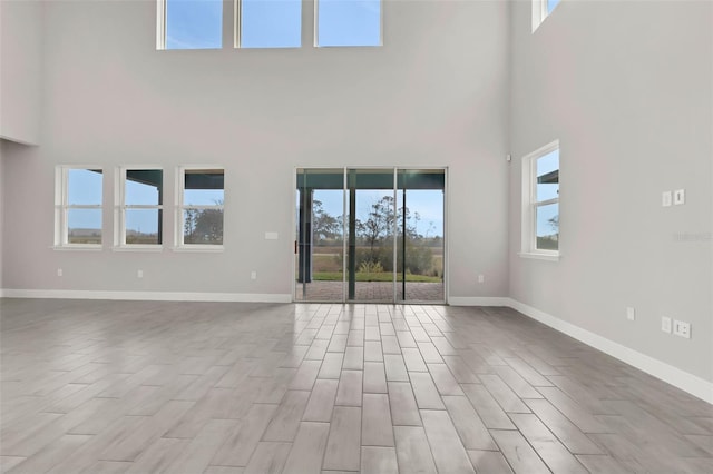 unfurnished living room featuring a high ceiling