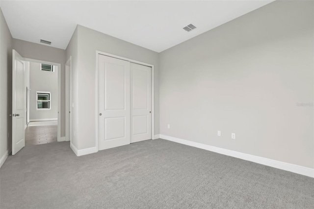 unfurnished bedroom featuring carpet and a closet