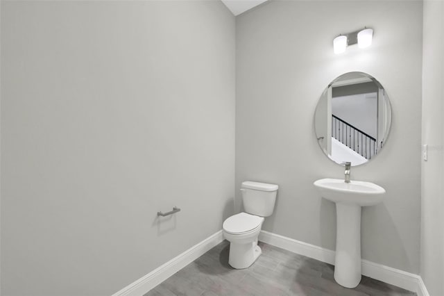 bathroom with wood-type flooring and toilet