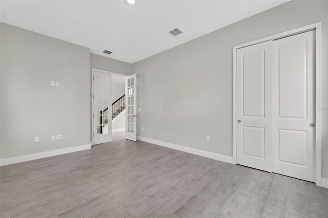 empty room with french doors and light hardwood / wood-style floors