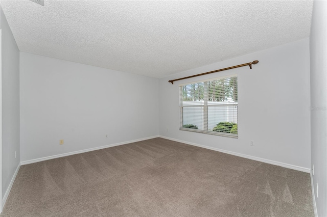 carpeted spare room with a textured ceiling