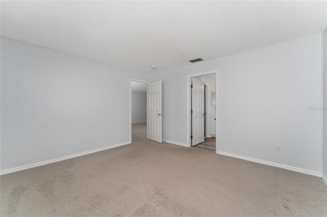 carpeted empty room featuring a textured ceiling