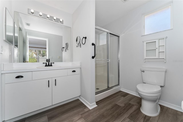 bathroom with wood-type flooring, vanity, toilet, and a shower with door