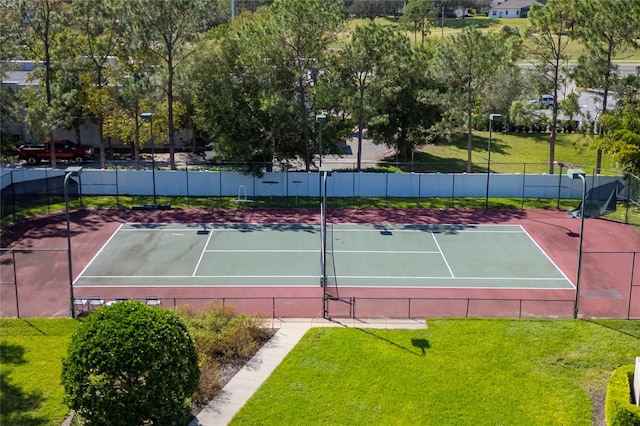 view of tennis court featuring a lawn