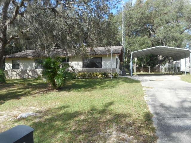 view of front of property with a front yard and a carport