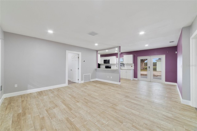 unfurnished living room featuring french doors and light hardwood / wood-style floors