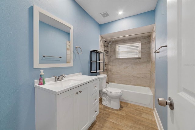 full bathroom featuring toilet, wood-type flooring, vanity, and tiled shower / bath combo