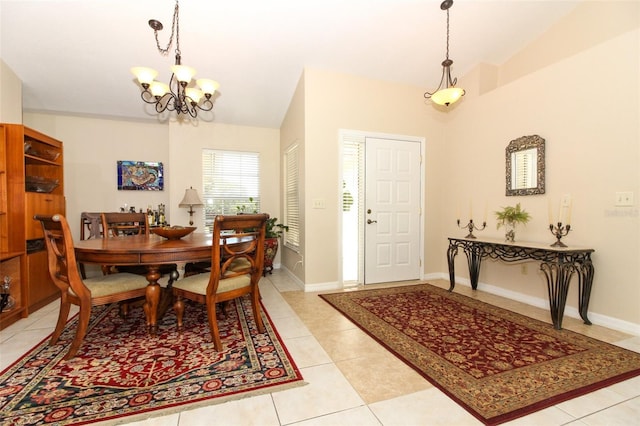 dining area with lofted ceiling, light tile patterned floors, and an inviting chandelier