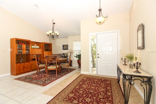 tiled entrance foyer with high vaulted ceiling and a chandelier