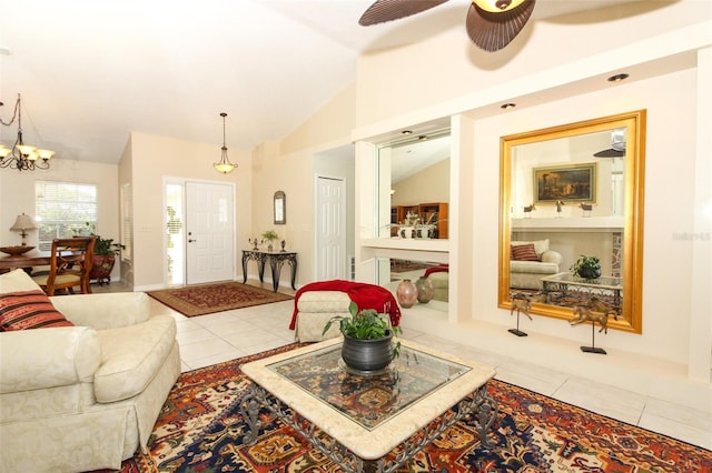 living room with ceiling fan with notable chandelier, light tile patterned floors, and vaulted ceiling