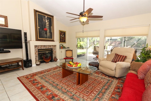 tiled living room featuring a tile fireplace, ceiling fan, and lofted ceiling