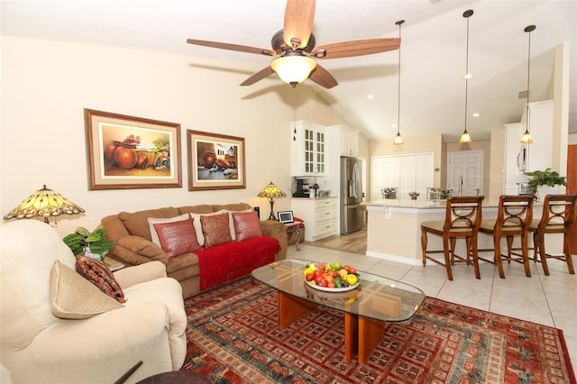 tiled living room with ceiling fan and vaulted ceiling