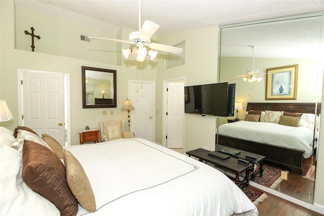 bedroom featuring wood-type flooring, a textured ceiling, vaulted ceiling, and ceiling fan