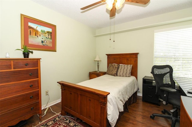 bedroom with a textured ceiling, ceiling fan, and dark wood-type flooring