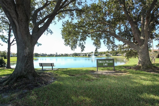 view of community with a lawn and a water view