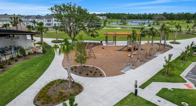 surrounding community with a water view, a playground, and a lawn