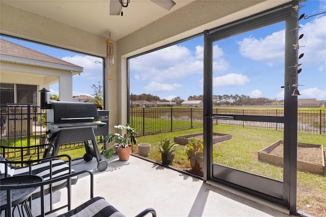 sunroom / solarium featuring ceiling fan, plenty of natural light, and a rural view