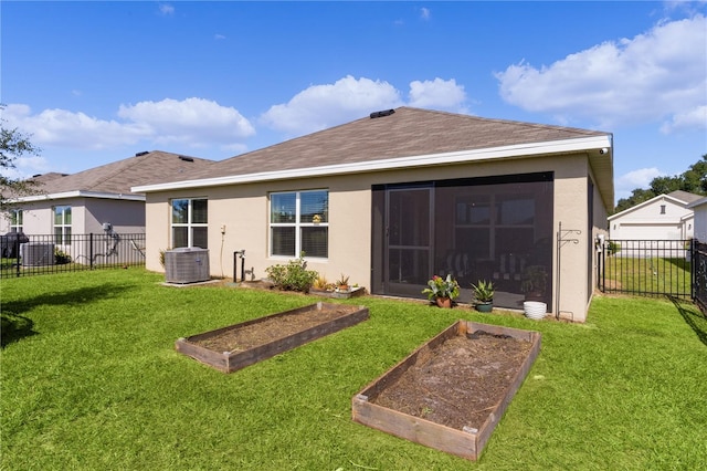 rear view of property with a lawn, central AC, and a sunroom