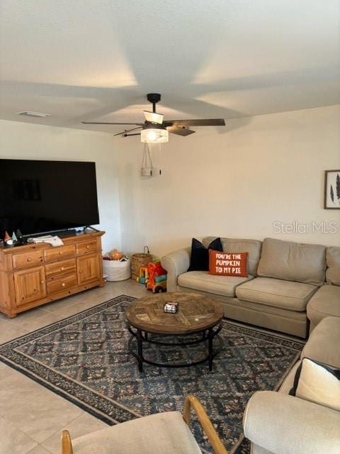 living room featuring light tile patterned floors and ceiling fan