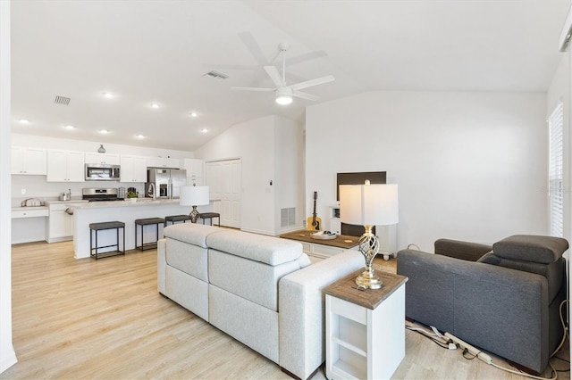 living room featuring light hardwood / wood-style flooring, lofted ceiling, and ceiling fan