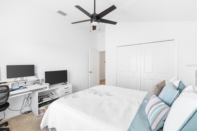 carpeted bedroom with a closet, high vaulted ceiling, and ceiling fan