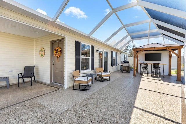 view of patio / terrace featuring grilling area, a lanai, and exterior bar