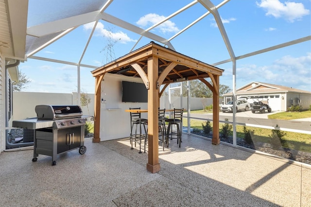 view of patio featuring a gazebo, a grill, exterior bar, and glass enclosure