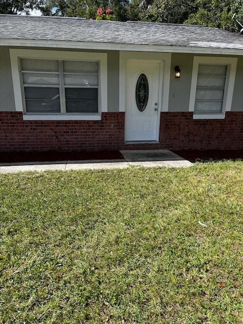 property entrance with a lawn