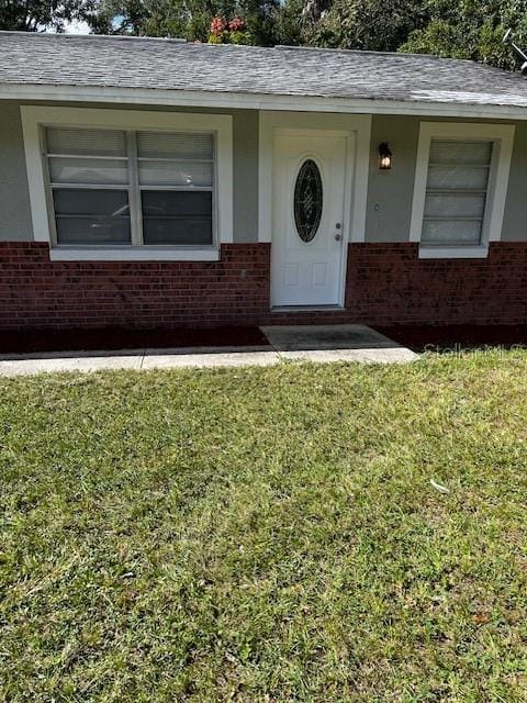 620 Gould St, Eustis, FL 32726 - doorway to property with brick siding and a yard
