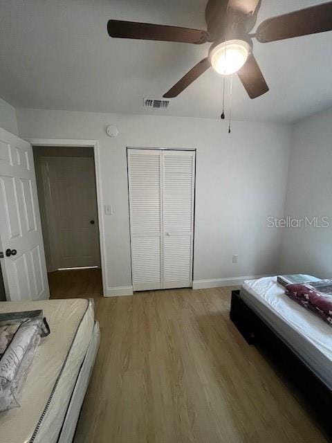 bedroom with a closet, ceiling fan, and hardwood / wood-style flooring