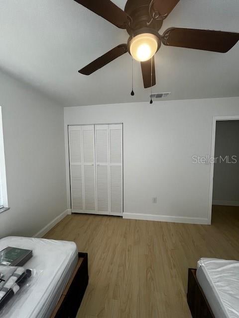 bedroom featuring light hardwood / wood-style flooring, a closet, and ceiling fan