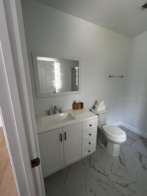 620 Gould St, Eustis, FL 32726 - bathroom featuring marble finish floors, toilet, vanity, and baseboards