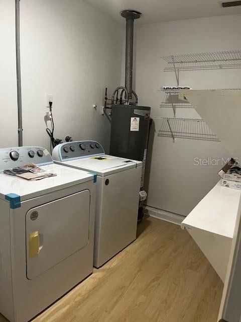 laundry area featuring light hardwood / wood-style floors, independent washer and dryer, and water heater