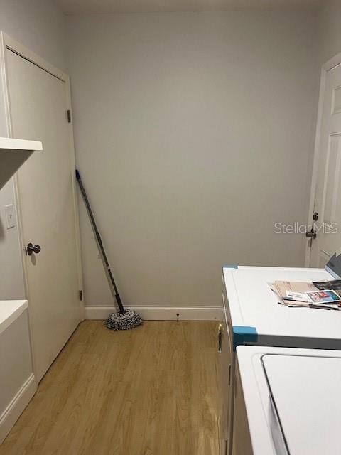 clothes washing area with light hardwood / wood-style flooring