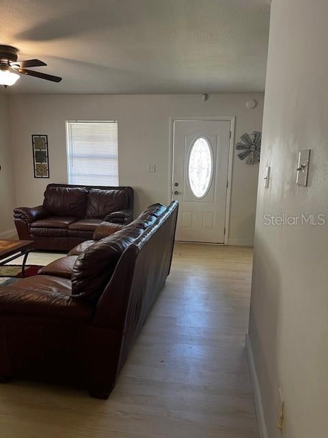 living room featuring light hardwood / wood-style flooring and ceiling fan