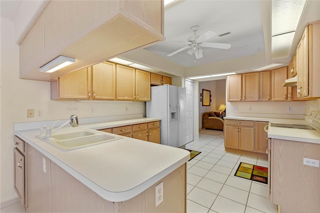 kitchen with kitchen peninsula, sink, light tile patterned flooring, light brown cabinetry, and white appliances