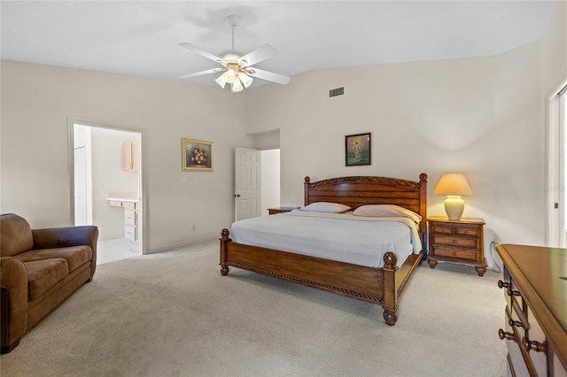 carpeted bedroom with connected bathroom, vaulted ceiling, and ceiling fan