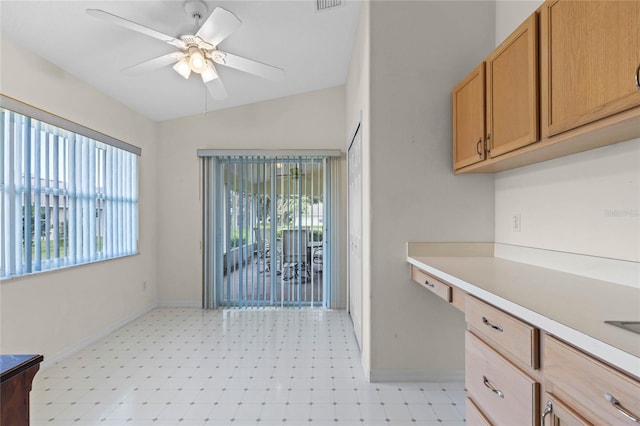 kitchen featuring built in desk, ceiling fan, lofted ceiling, and plenty of natural light