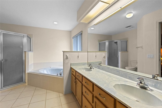 full bathroom with a textured ceiling, separate shower and tub, toilet, tile patterned floors, and vanity